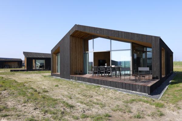 Natuurhuis met overdekt terras aan water in Zeelandse polder - thumbnail 1